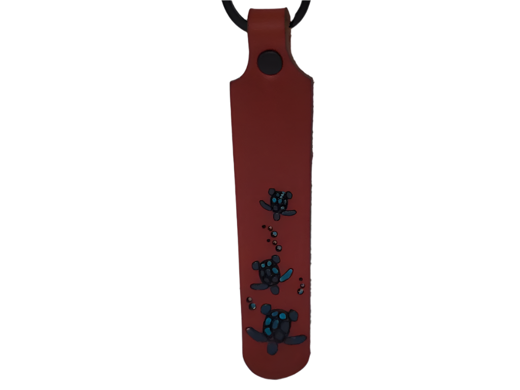 Brown leather keychain with black turtle design on a white background