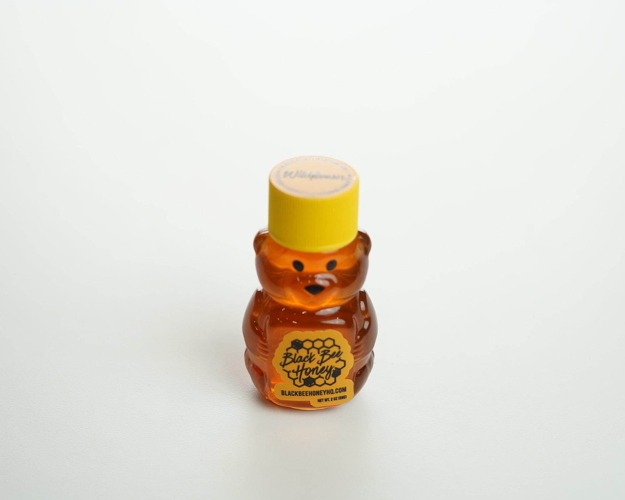 Bear-shaped honey bottle on a white background
