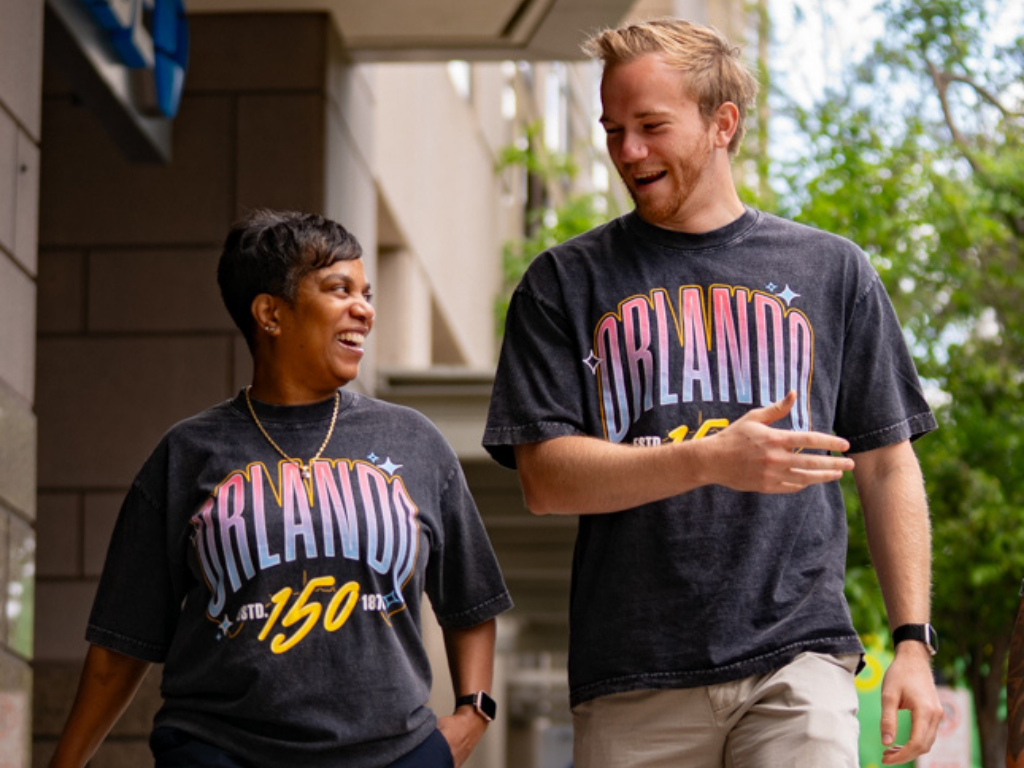 Two people wearing Orlando-themed t-shirts walking outdoors